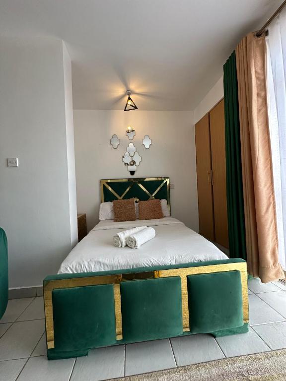 a bedroom with a bed with a green and white bed frame at Luxe Haven in Nairobi