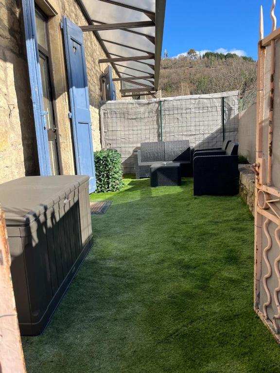 a backyard with green grass and a patio at L'Echappée Verte Climatisée in Marvejols