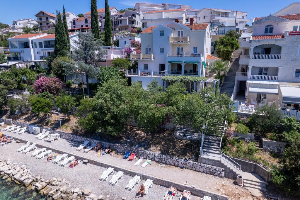 a view of a beach with chairs and buildings at Villa Obad Guest House in Neum