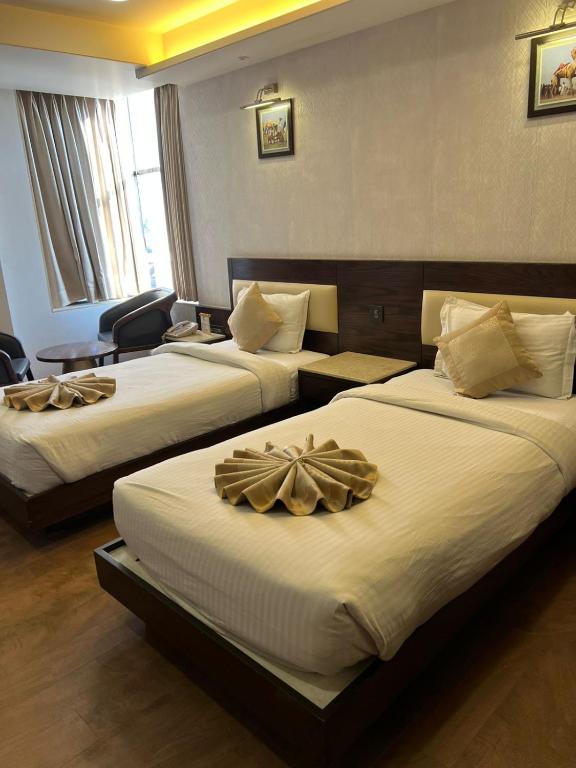a hotel room with two beds with bows on them at The Crystal Park in Kishangarh