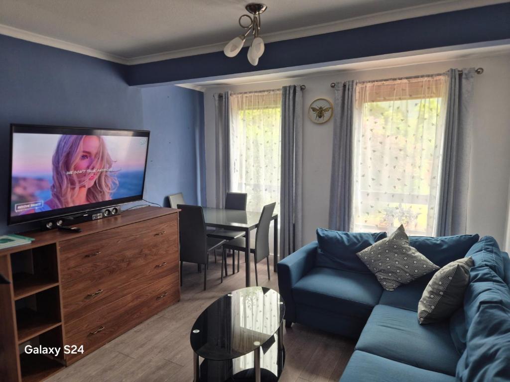 a living room with a blue couch and a television at Millers Ben Nevis View in Caol