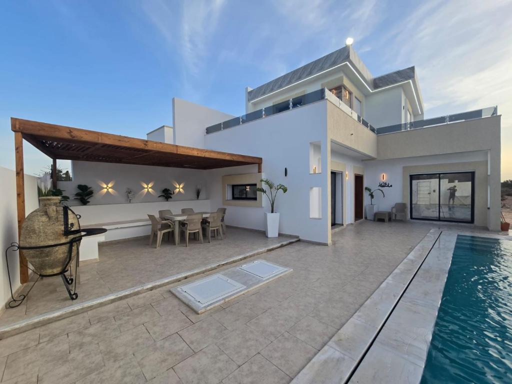 a villa with a swimming pool and a house at Dar Aalya in Djerba