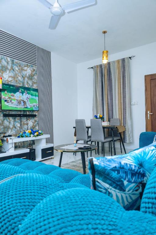 a living room with a couch and a tv at MtaaLiving-Bamburi in Mombasa