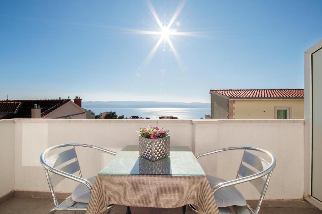 a table and chairs on a balcony with a view at Sunny house KIMI in Omiš