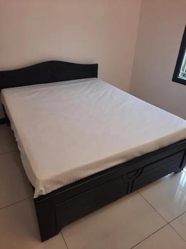 a bed in a room with a white mattress at Arrow mansion in Kolli Hills