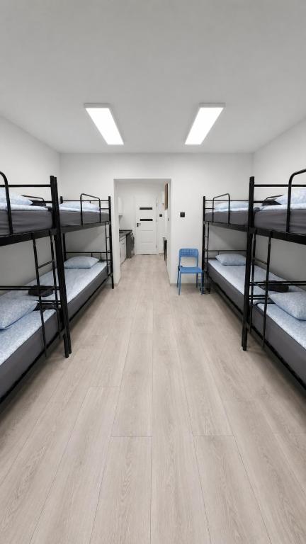 a room with four bunk beds and a wooden floor at Przystanek Wałbrzych in Wałbrzych