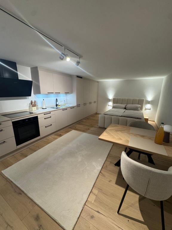 a living room with a table and a kitchen at Casa Souterrain in Immenstaad am Bodensee