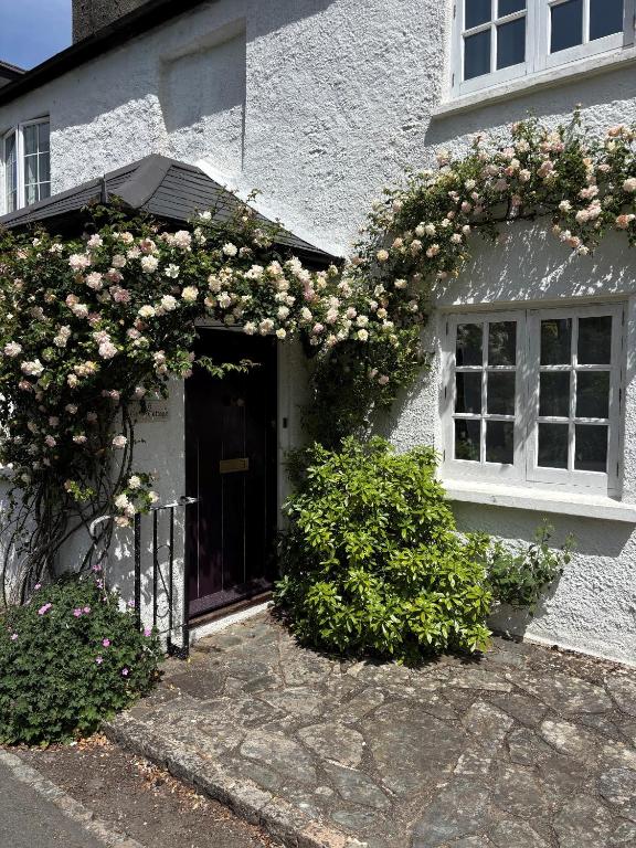 a white house with a bunch of flowers on it at Gorse cottage in Newton Abbot