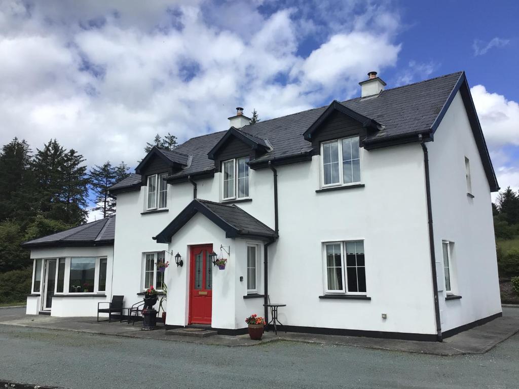 a white house with a red door at Apartment in Coolea in Bard Inch