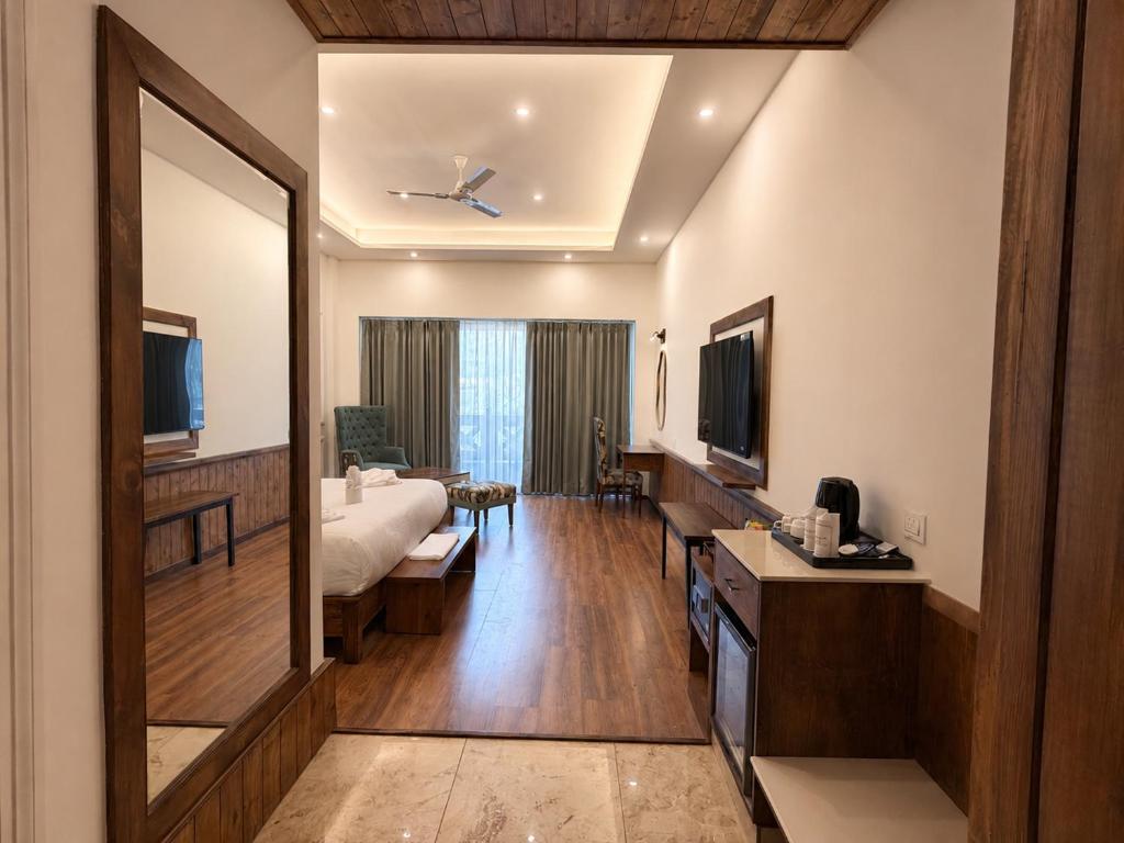 a hotel room with a bed and a large mirror at The himalayan chester in Manāli