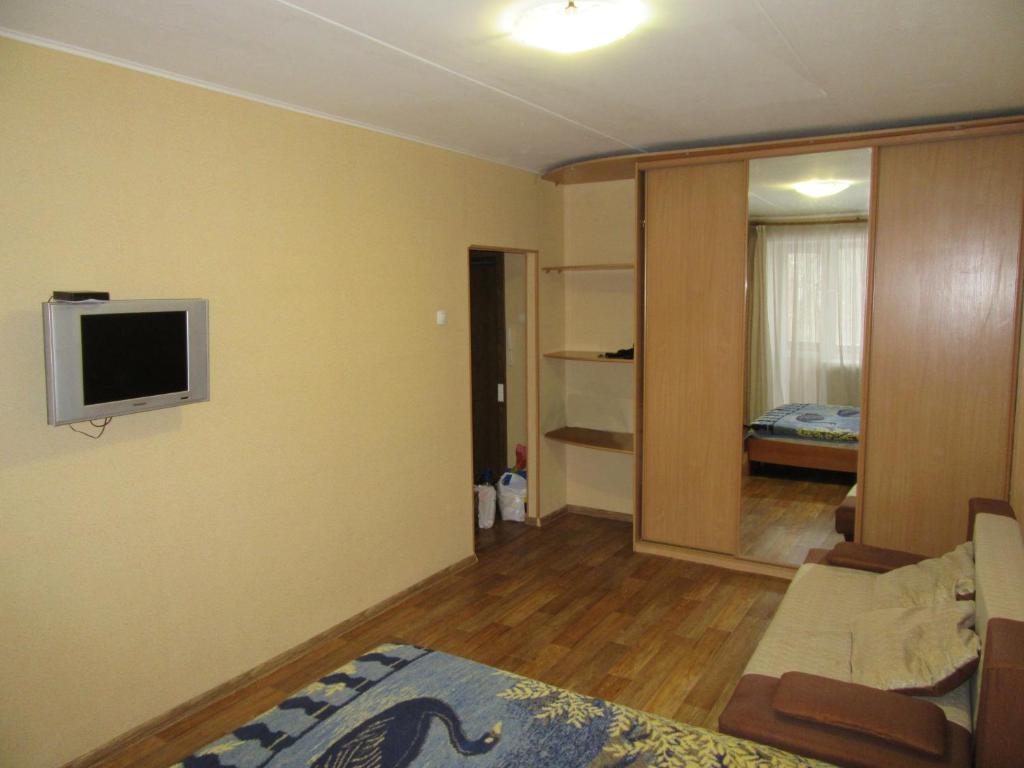 ペルミにあるApartments On Leninaのリビングルーム(ソファ、壁掛けテレビ付)