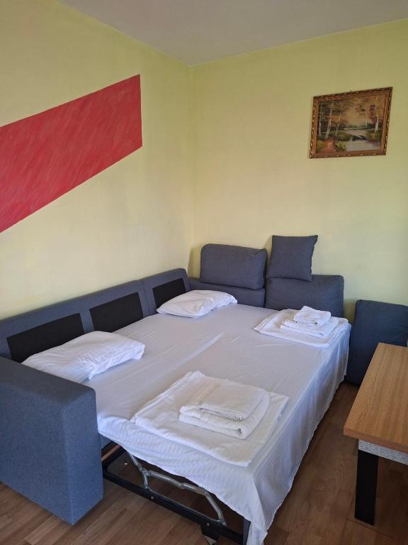 a bedroom with two beds and a table in it at Apartmani Lazić No 5 in Gracanica