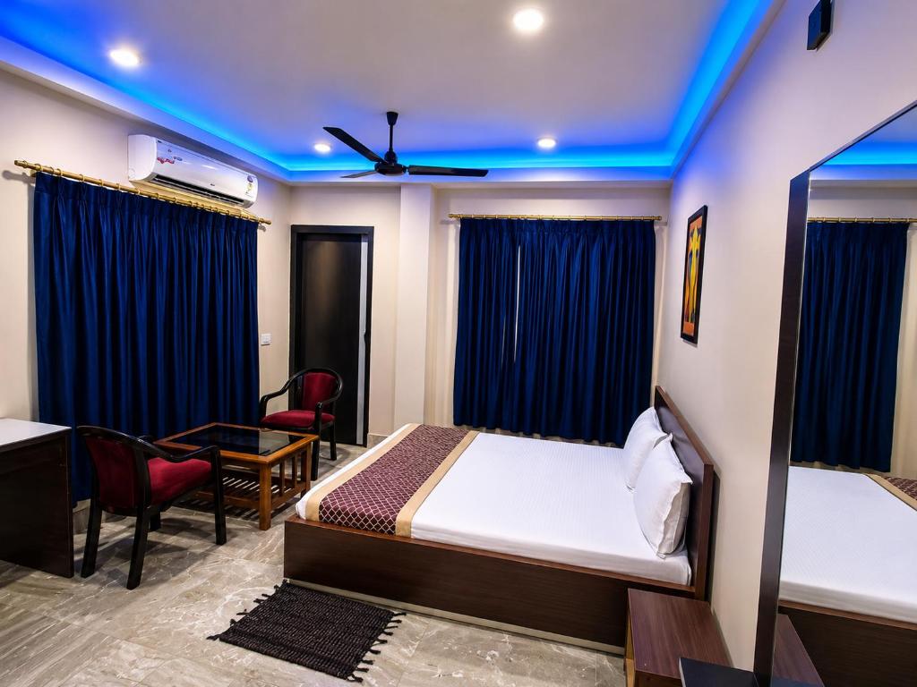 a hotel room with a bed and a table and chairs at Hotel #Blue Moon# Front Of Bhubaneswar Railway Station in Bhubaneshwar