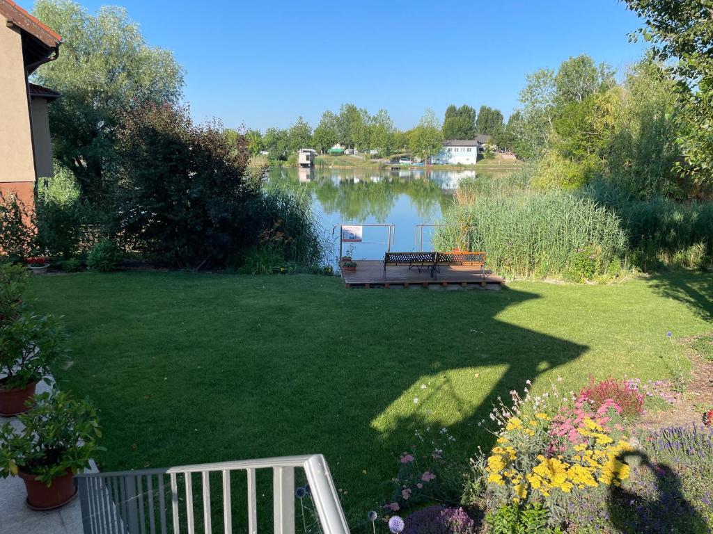 a yard with a picnic table and a lake at Apartmány Silvia in Dunajská Streda