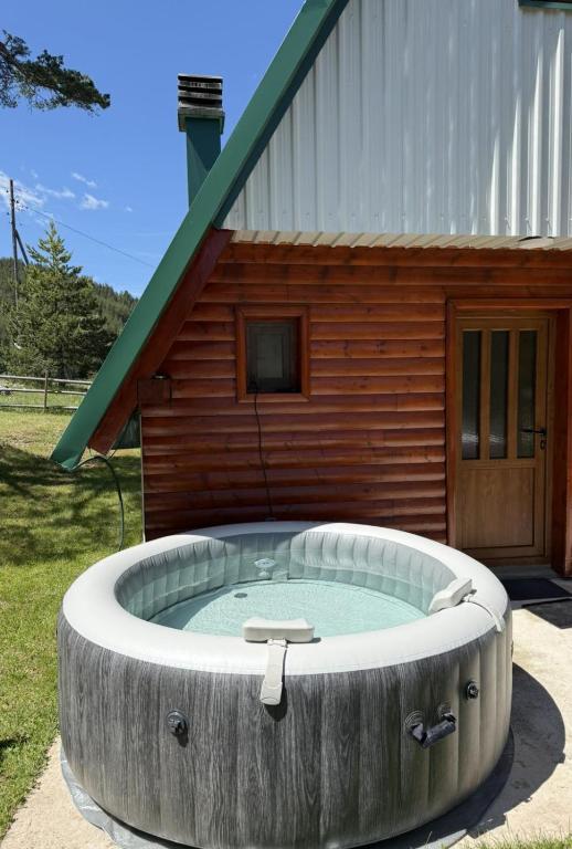 a large circular hot tub in front of a building at Zabljak_vikendica in Žabljak