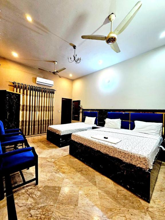 a bedroom with two beds and a ceiling fan at Royal Villa in Karachi