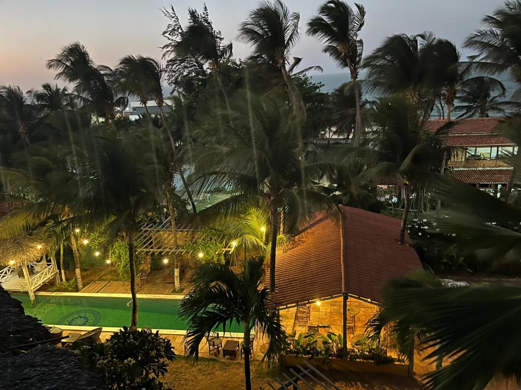 a view of a resort with palm trees and a pool at Wind & Sun Kite Pousada in Canoa Quebrada