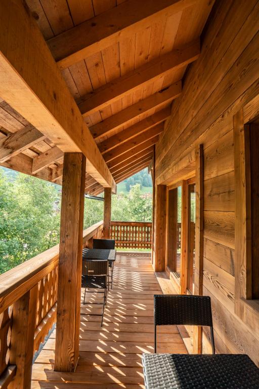 a wooden porch with chairs and a wooden ceiling at CHALET LES CERFS in Châtel