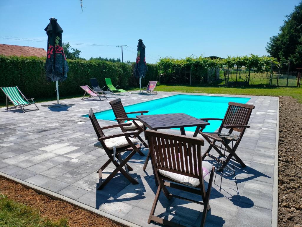 a table and chairs next to a swimming pool at apartma "happy Scotts" in Starše