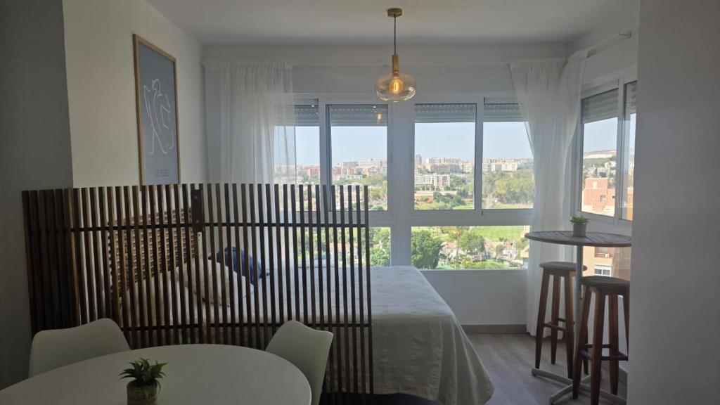 a bedroom with a bed and a table and a window at Estudio Bellavista La Colina in Torremolinos