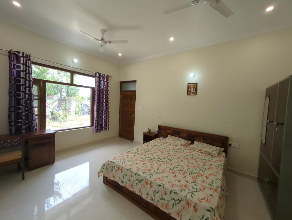 a bedroom with a bed and a large window at Panchsheel Villa Bhimtal in Bhīm Tāl