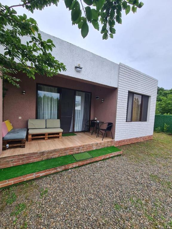 a house with a wooden deck with a couch at MAG house in Shekhvetili