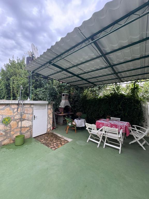 a patio with a table and chairs under a canopy at Whole house Ariela, 20m to the beach, has a barbecue, 2 terraces in Šibenik