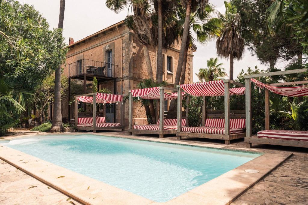 a swimming pool with chairs and a house at Villa Station by Cassai in Ses Salines