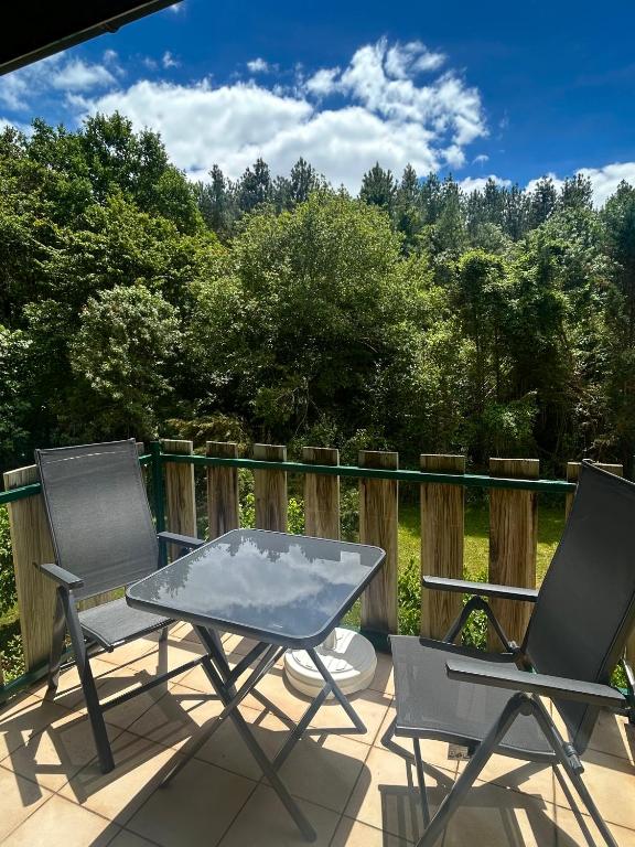 a patio with two chairs and a table on a deck at Studio ensoleillé avec piscine in Cazaubon