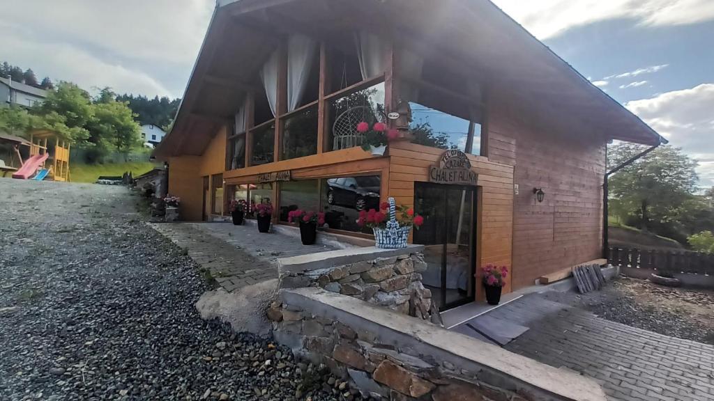 ein Haus mit einer Steinmauer und einem Gebäude in der Unterkunft Chalet Alina in Borşa