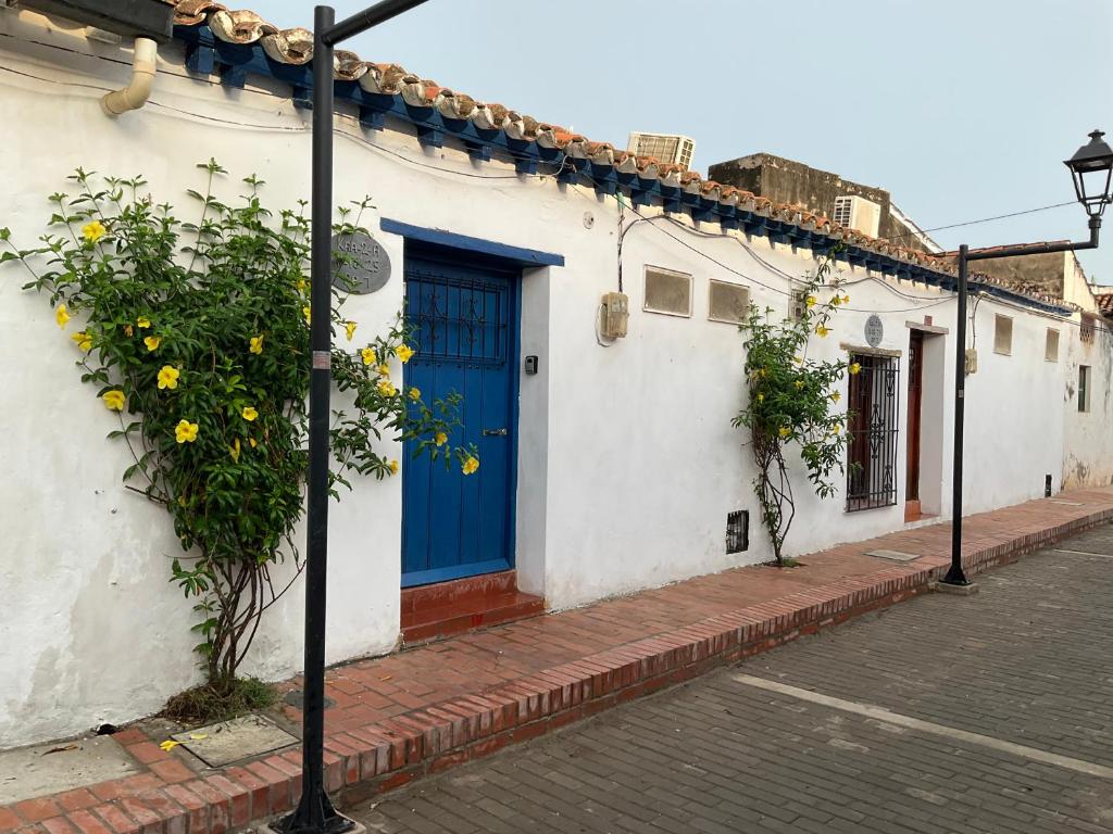 a blue door on the side of a white building at Casa colonial Centro Histórico - Puerta Azul in Mompos