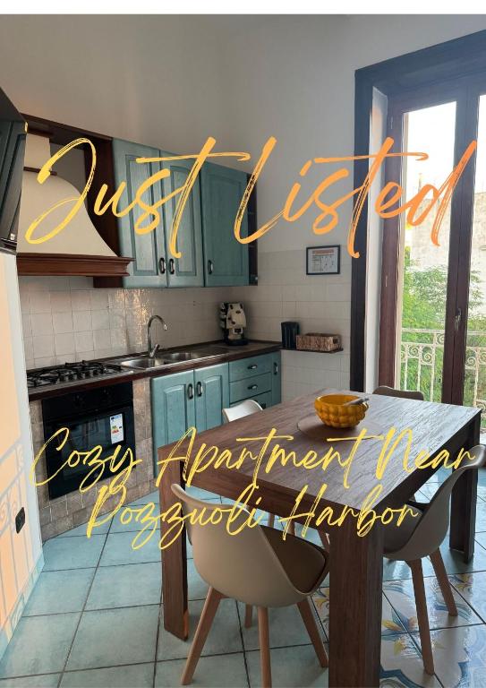 a kitchen with green cabinets and a wooden table at Sibilla Flegrea in Pozzuoli