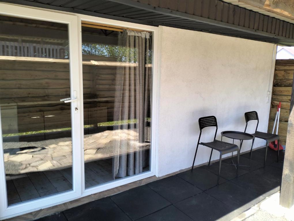 a screened in porch with two chairs and a table at Krainya hata in Szack