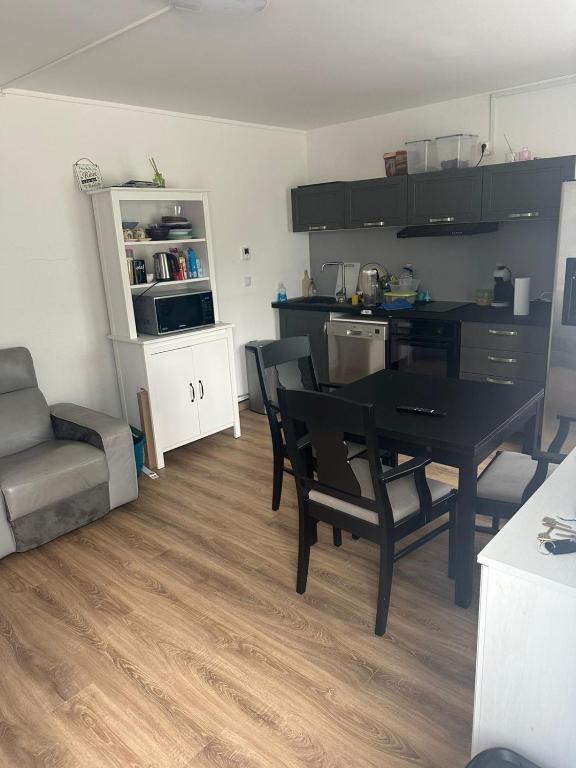 a kitchen and dining room with a black table and chairs at Malkom house in Gien