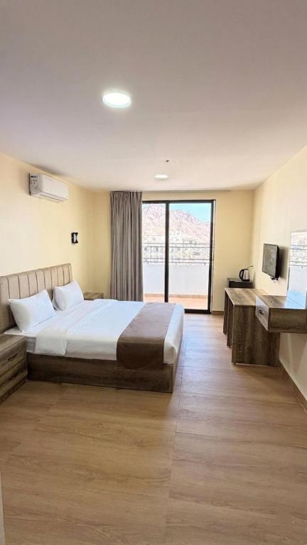 a hotel room with a bed and a large window at Selena Hotel Aqaba in Aqaba