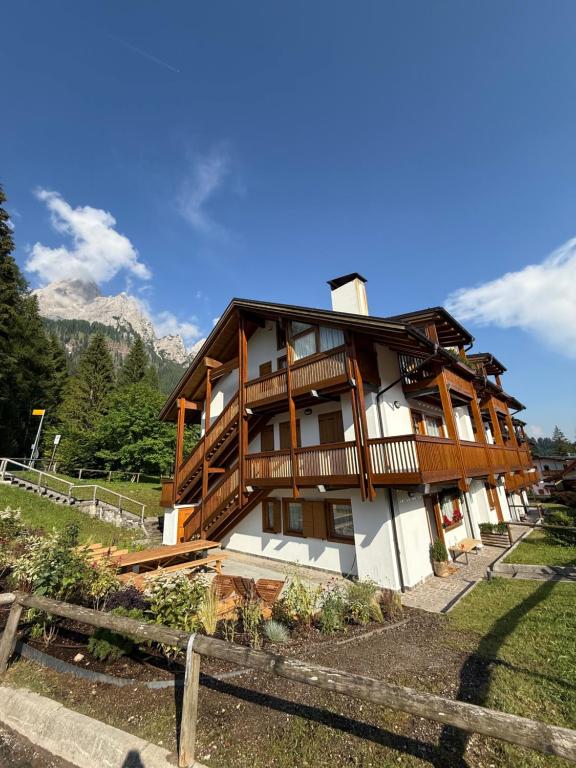 a wooden house with a fence in front of it at Appartamento Val Di Roda in San Martino di Castrozza