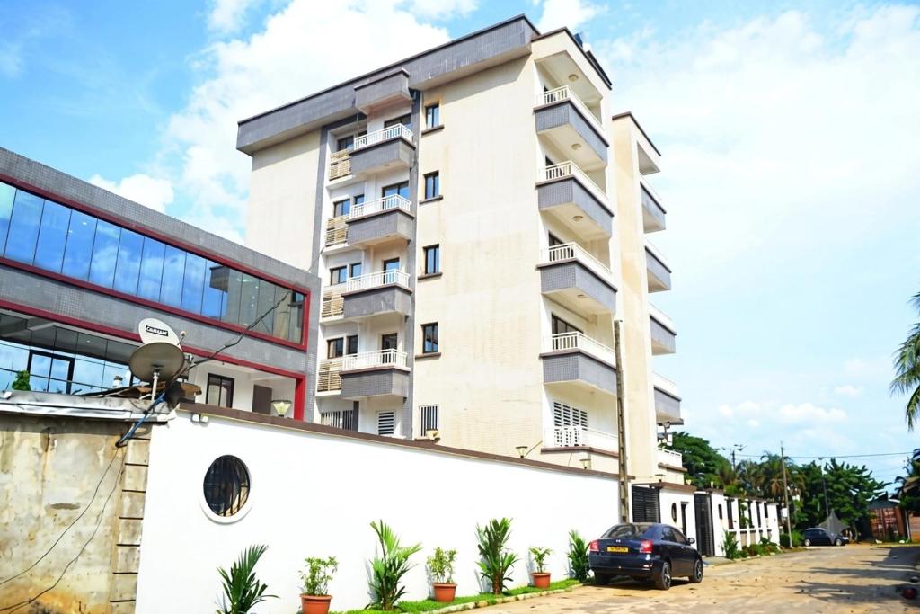 a building with a car parked in front of it at jPALACE in Bonamoussadi