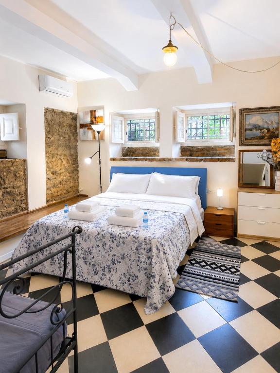 a bedroom with a bed and a checkered floor at La Roccia in Reggio di Calabria