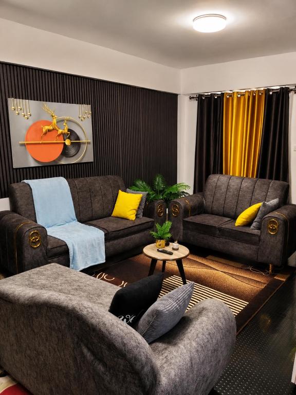 a living room with two couches and yellow pillows at Eldo oasis in Eldoret