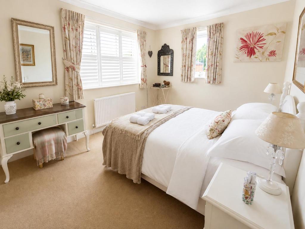 a bedroom with a large white bed and a desk at Two Ducks Cottage by NewFo dot Rest in Lyndhurst