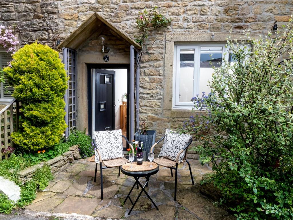 two chairs and a table in front of a house at Rosemount Cottage in Salterforth
