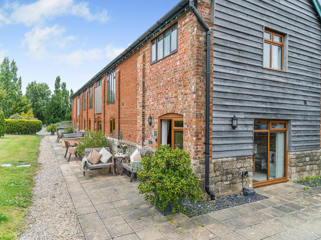 a brick building with tables and chairs in front of it at Byre - Uk49899 in Blandford Forum