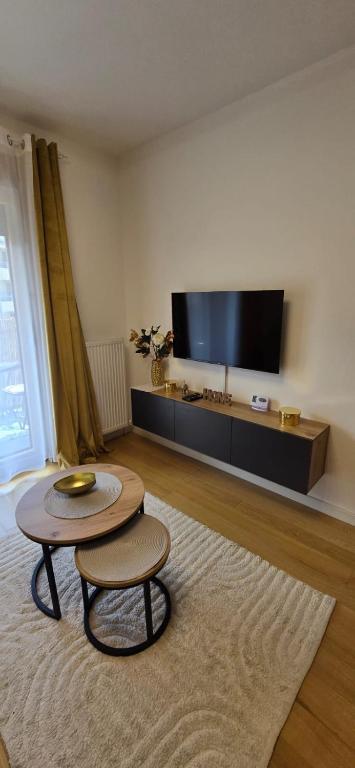 a living room with a table and a flat screen tv at Apartman Raj VV sa garazom Vrnjačka Banja in Vrnjci