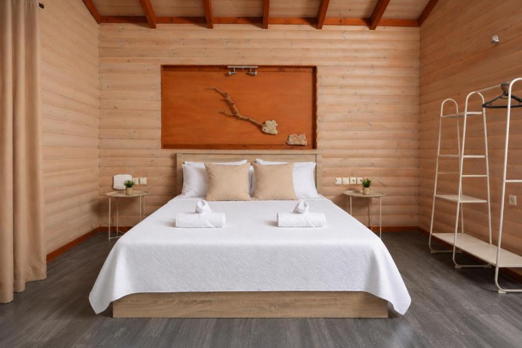 a bedroom with a large white bed with two tables at Hilltop Chalet 4 in Hanioti