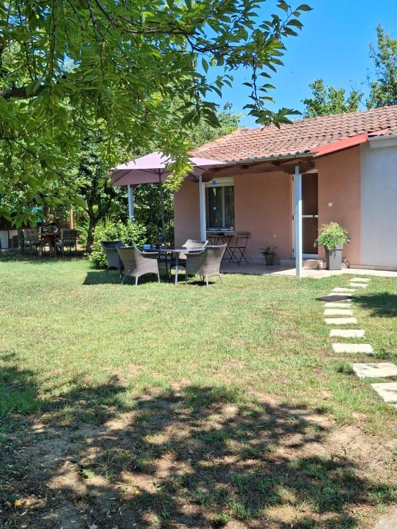 a house with a table and chairs in a yard at Avli Cozy Home in Karditsomagoúla
