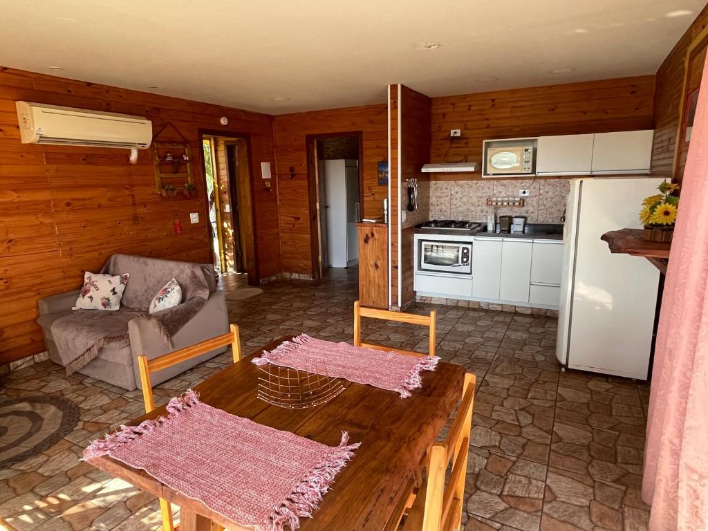 a living room with a table and a kitchen at Swiss Chalets - Thermas Water Park in Águas de São Pedro