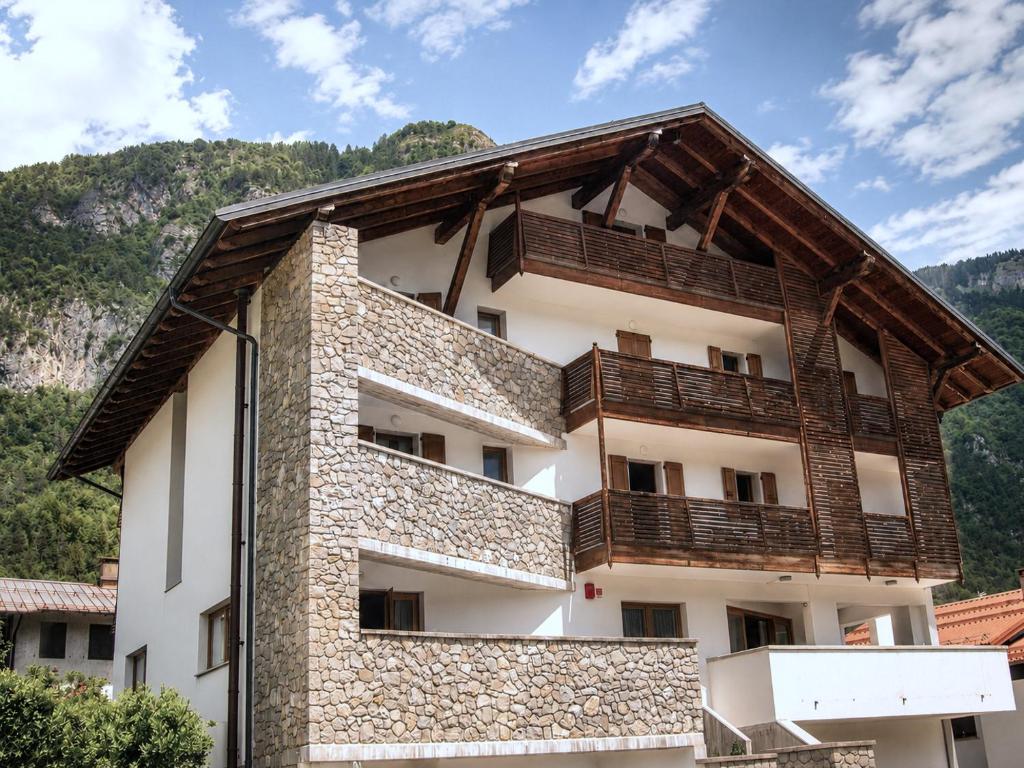 a building with wooden balconies on the side of it at Hotel Radis in Forni di Sotto