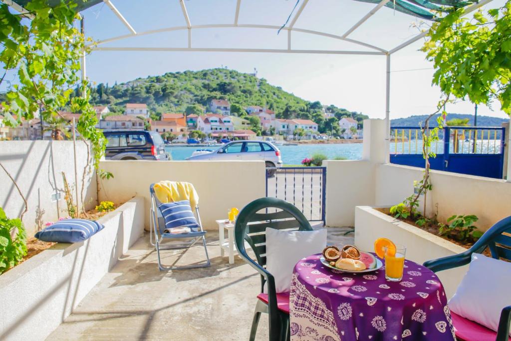 a table and chairs on a balcony with a view of the water at Apartment Mihovil 308 in Tisno