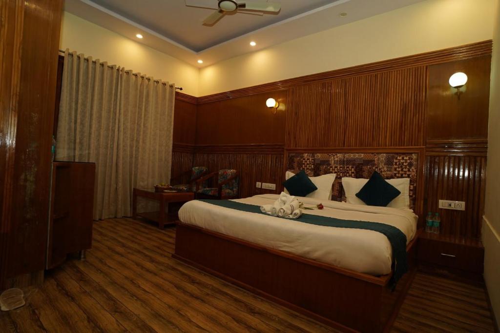 a bedroom with a large bed in a room at Vasant Corbett Resort By Mannat in Rāmnagar