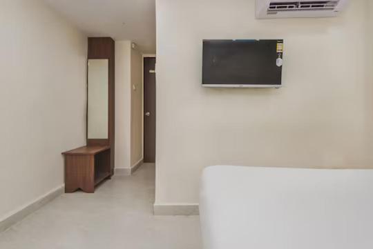 a room with a flat screen tv on a wall at Uma Residency - Chakala in Mumbai